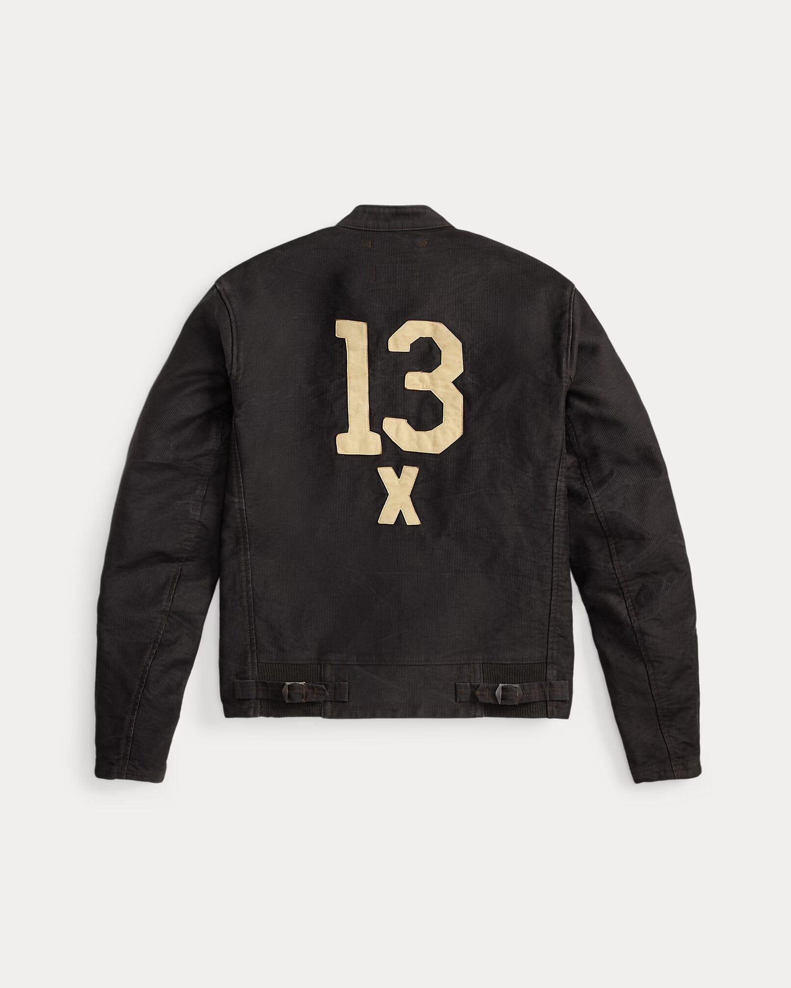 A black corduro jacket shown from the back, featuring a distressed gold '13 X' graphic printed on the upper back, set against a light gray background.