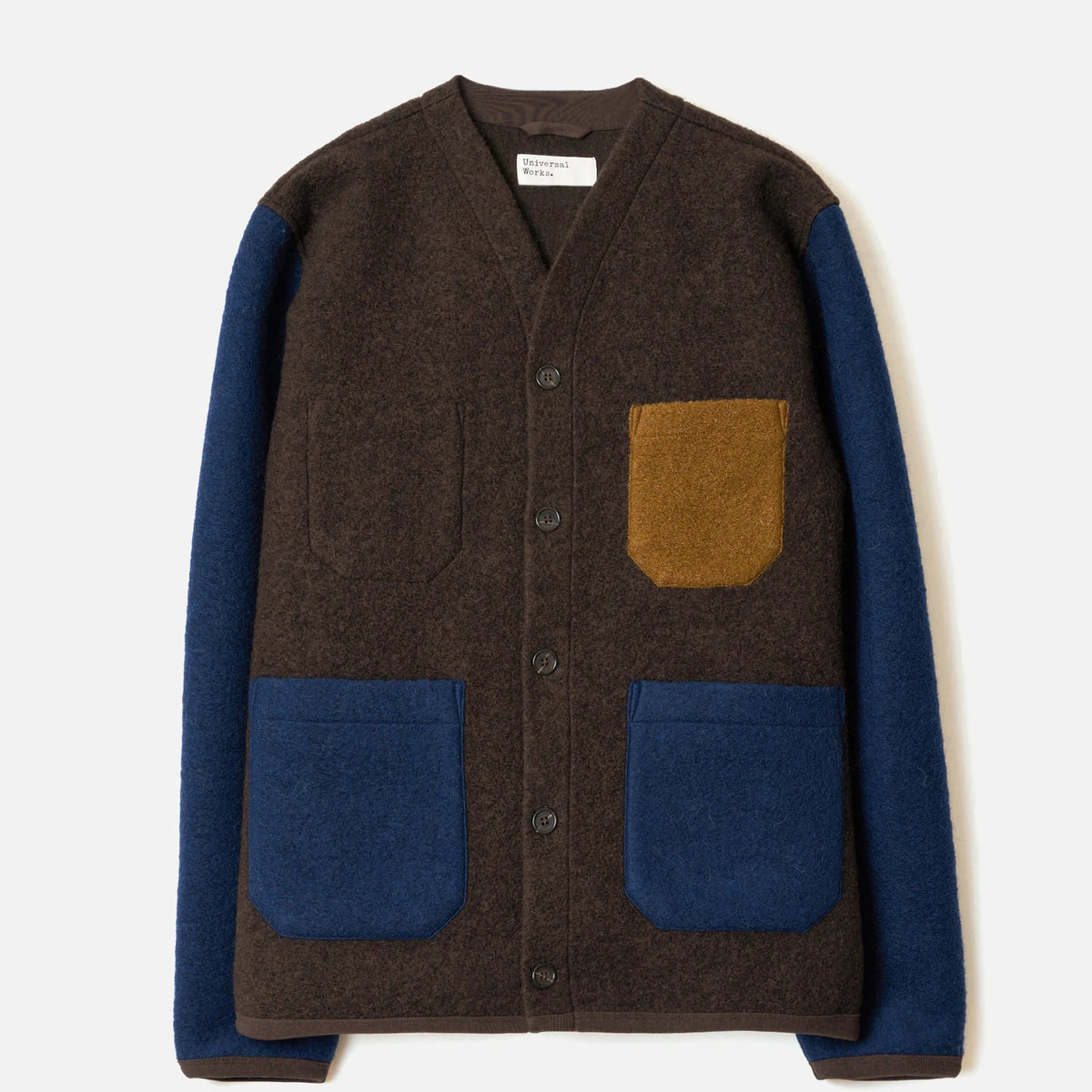 A brown wool-blend cardigan sweater with contrasting navy blue sleeves and pockets, featuring a tan pocket on the chest, displayed flat against a light off-white background.